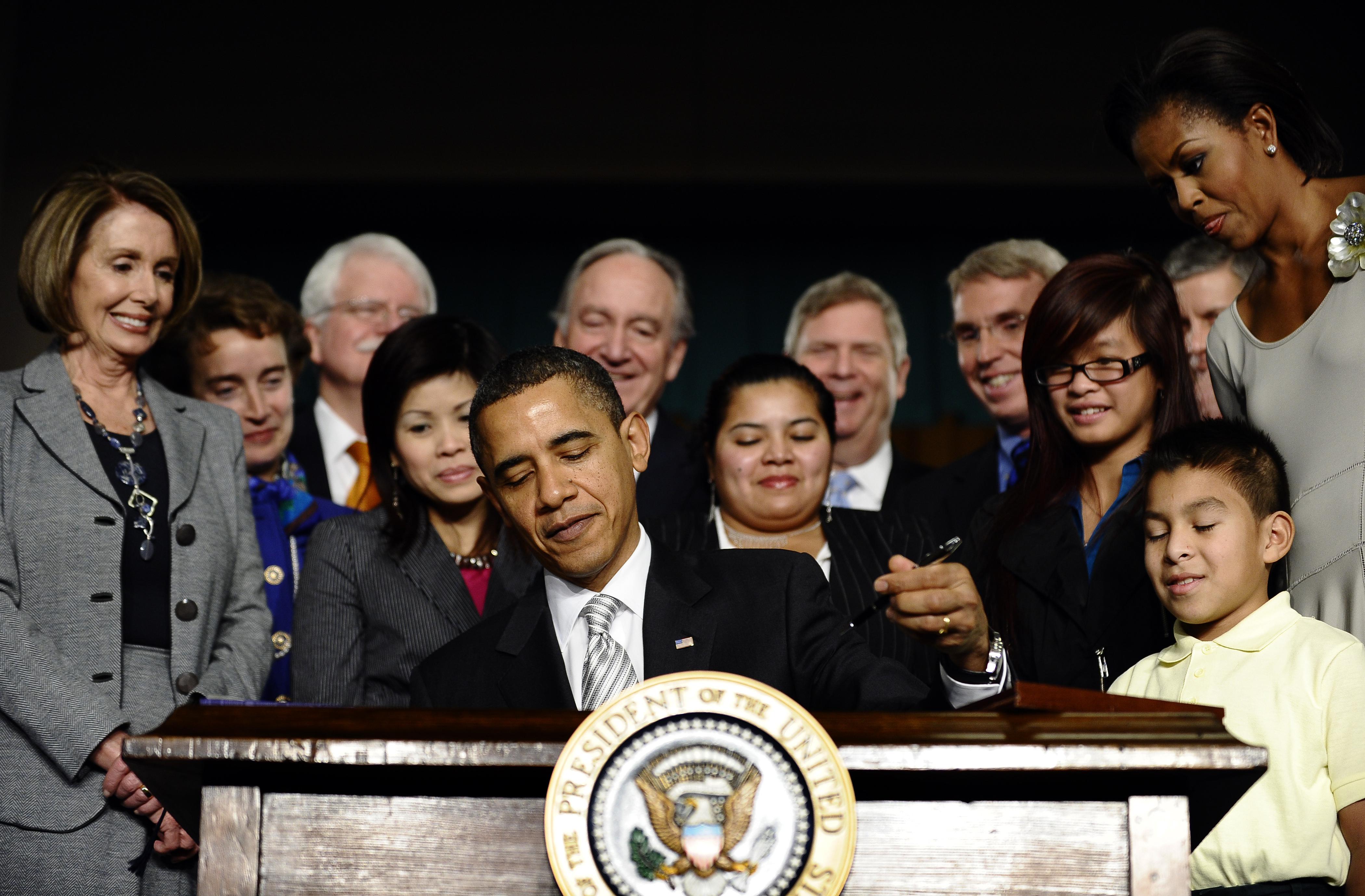 US President Barack Obama signs into law