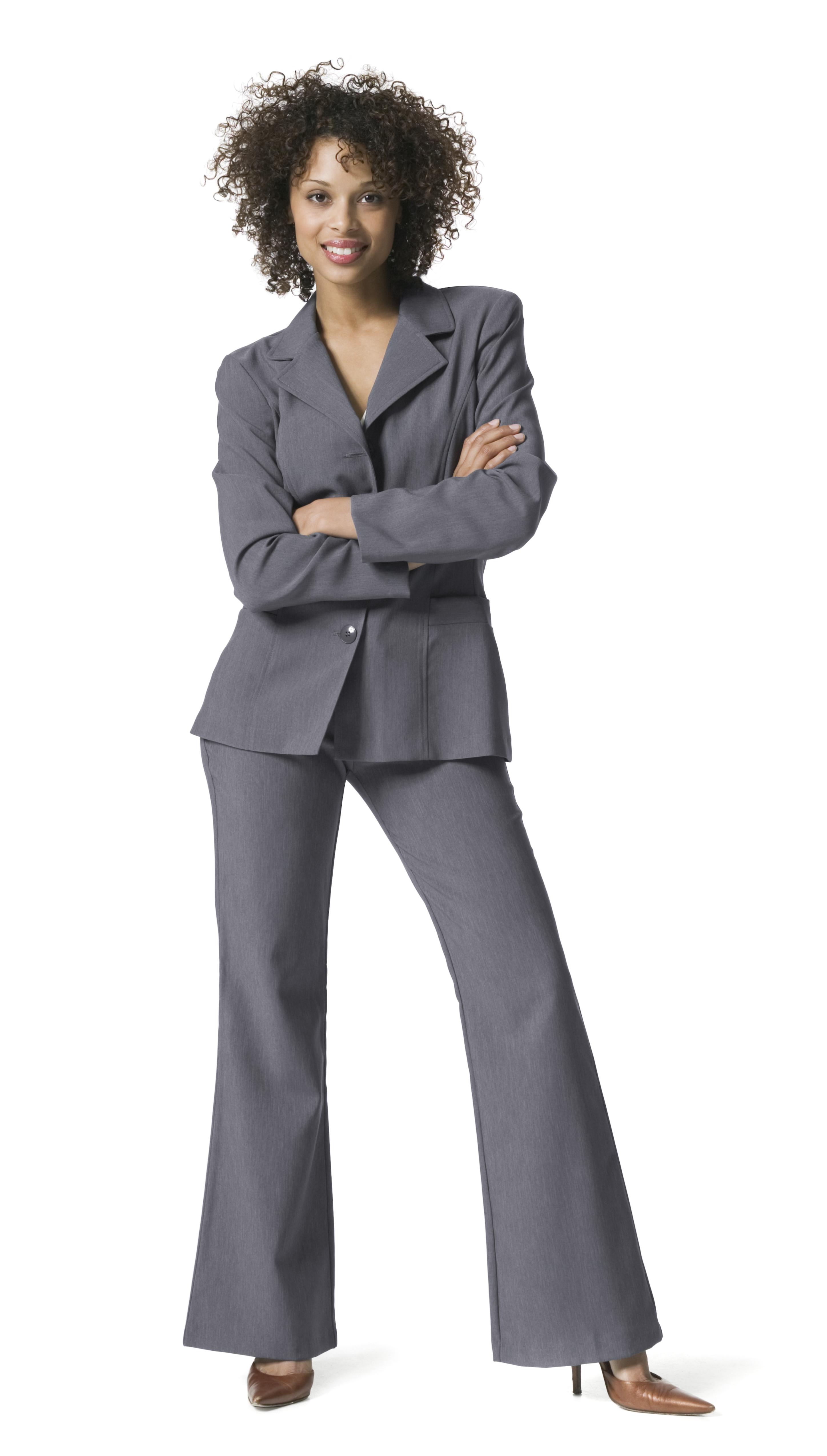 full length business portrait of a young adult woman in a grey suit as she folds her arms and smiles