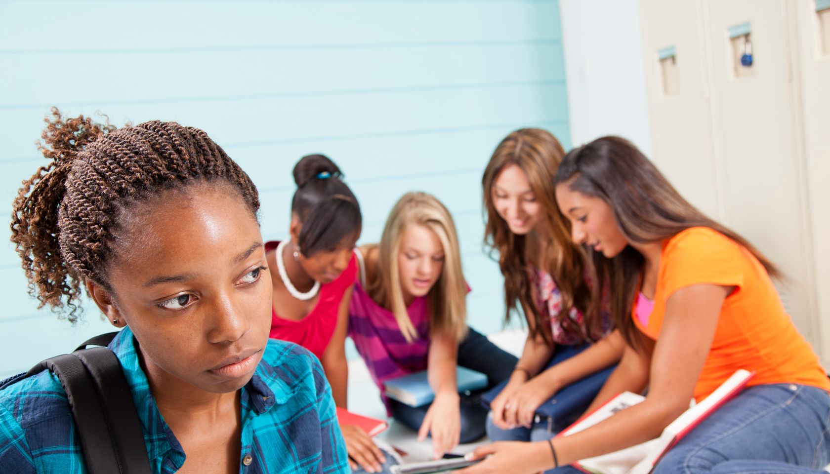 Teenage girls bully classmate. Gossip, talking. School hall. Lockers.