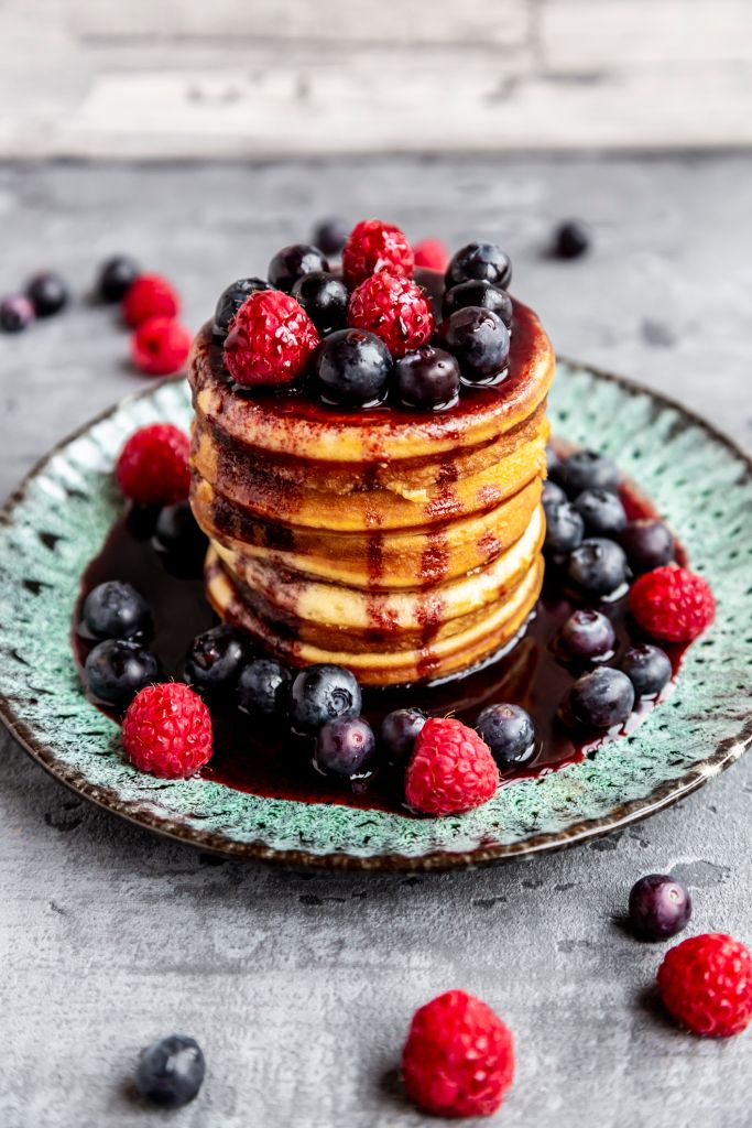 Pancakes with blueberries, raspberries and black currant sirup