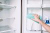 Cropped Hands Of Woman Cleaning Fridge At Home