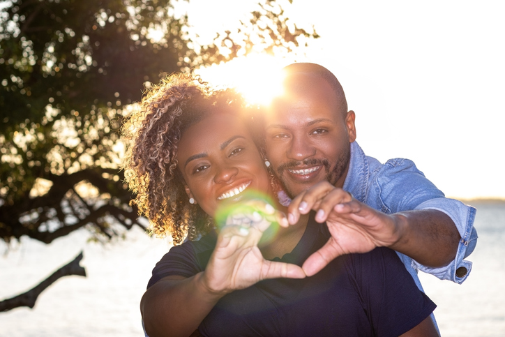 Portrait of a newly married couple making a heart to the camera