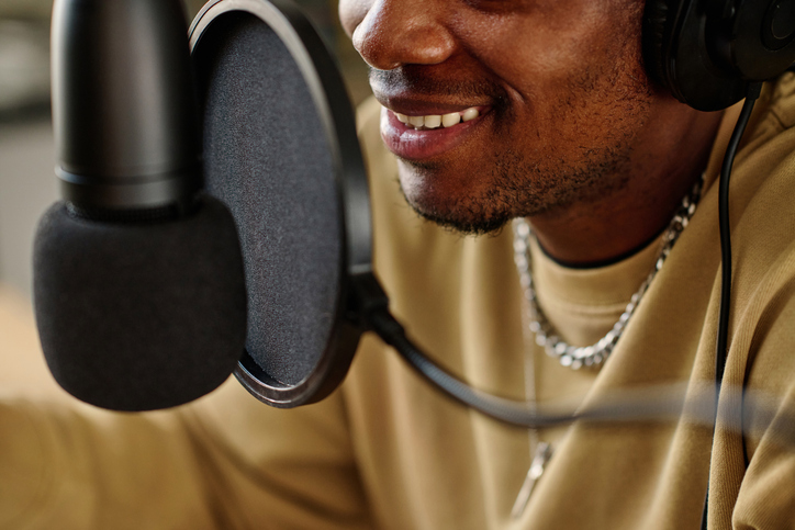 Smile of young African American male host speaking in microphone